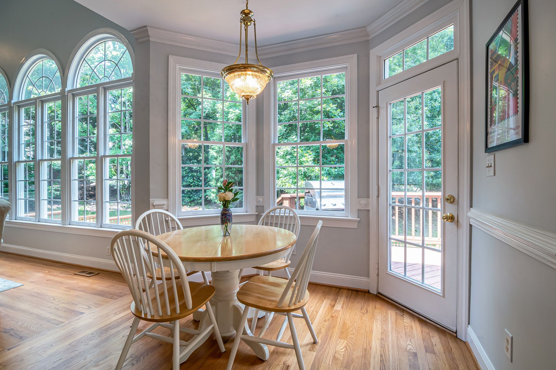 Bright and cozy dining area with round table and chairs, surrounded by glass windows in Austin, TX