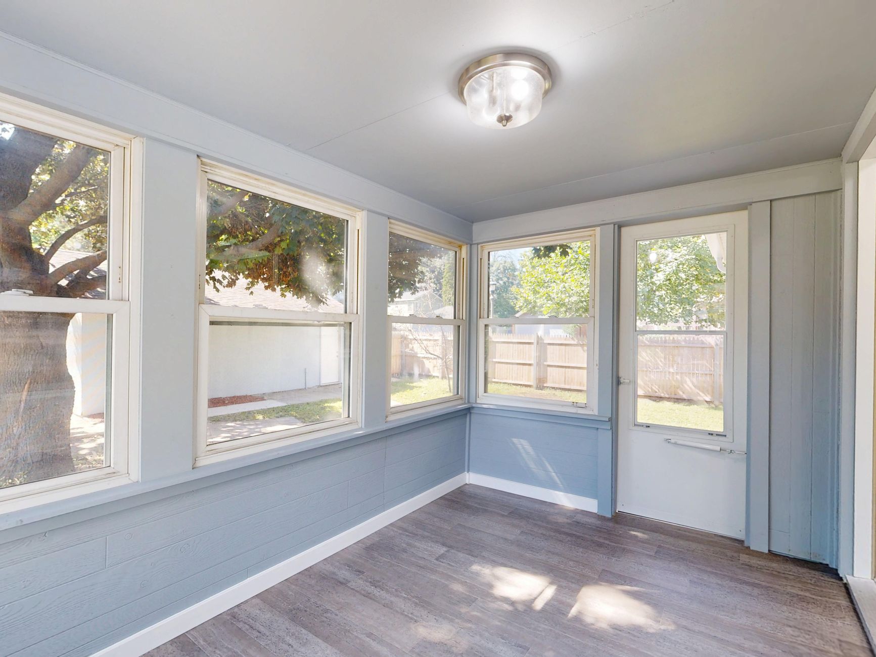 Spacious sunroom with large windows, natural light, and modern flooring in Austin, TX